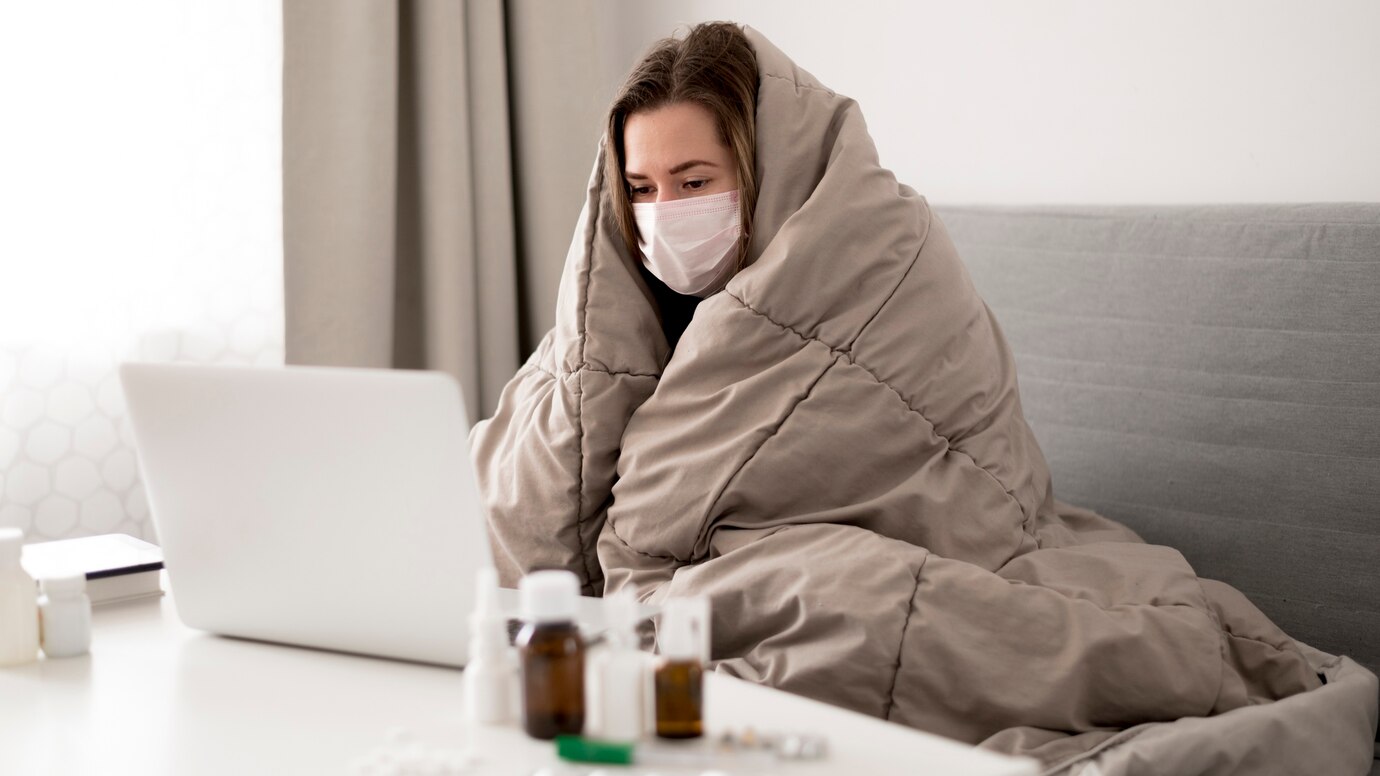 Chica arropada con mascarilla quirúrgica. Persona con el sistema inmune debilitado, inmunosuprimida por los tratamientos.