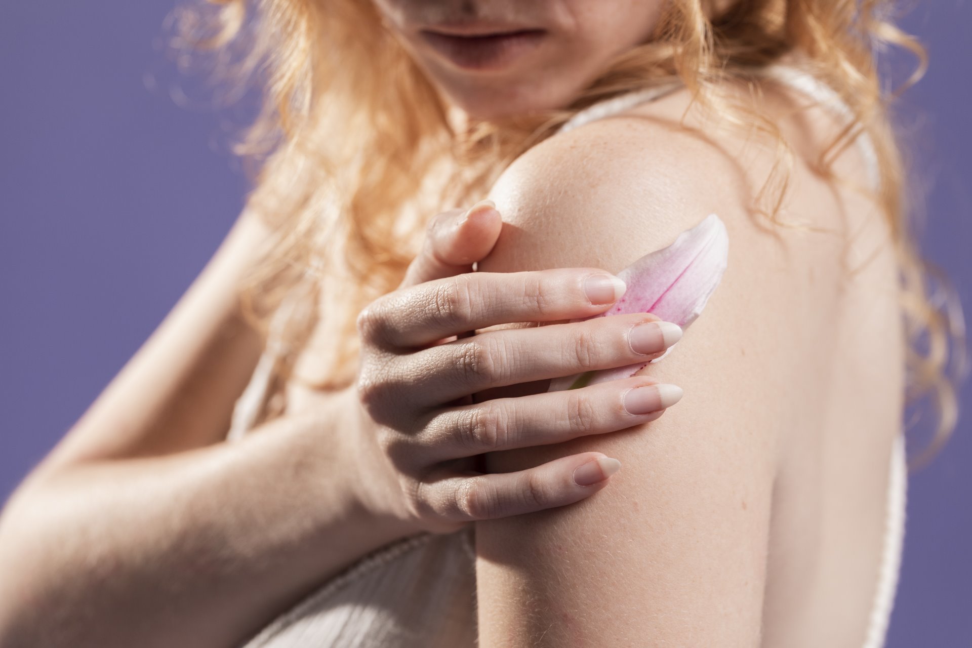 Mujer mirándose brazo y cubriéndose una erupción por psoriasis