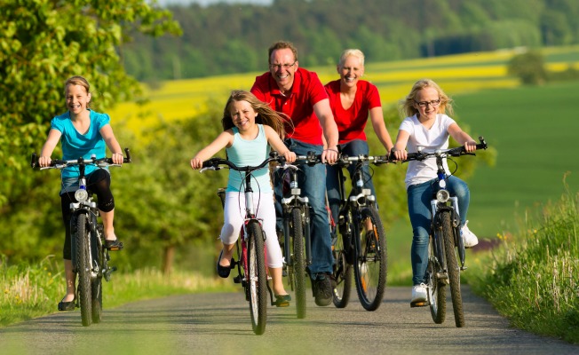 Factores que afectan los niveles de serotonina. Ilustrado por una familia en bicicleta.
