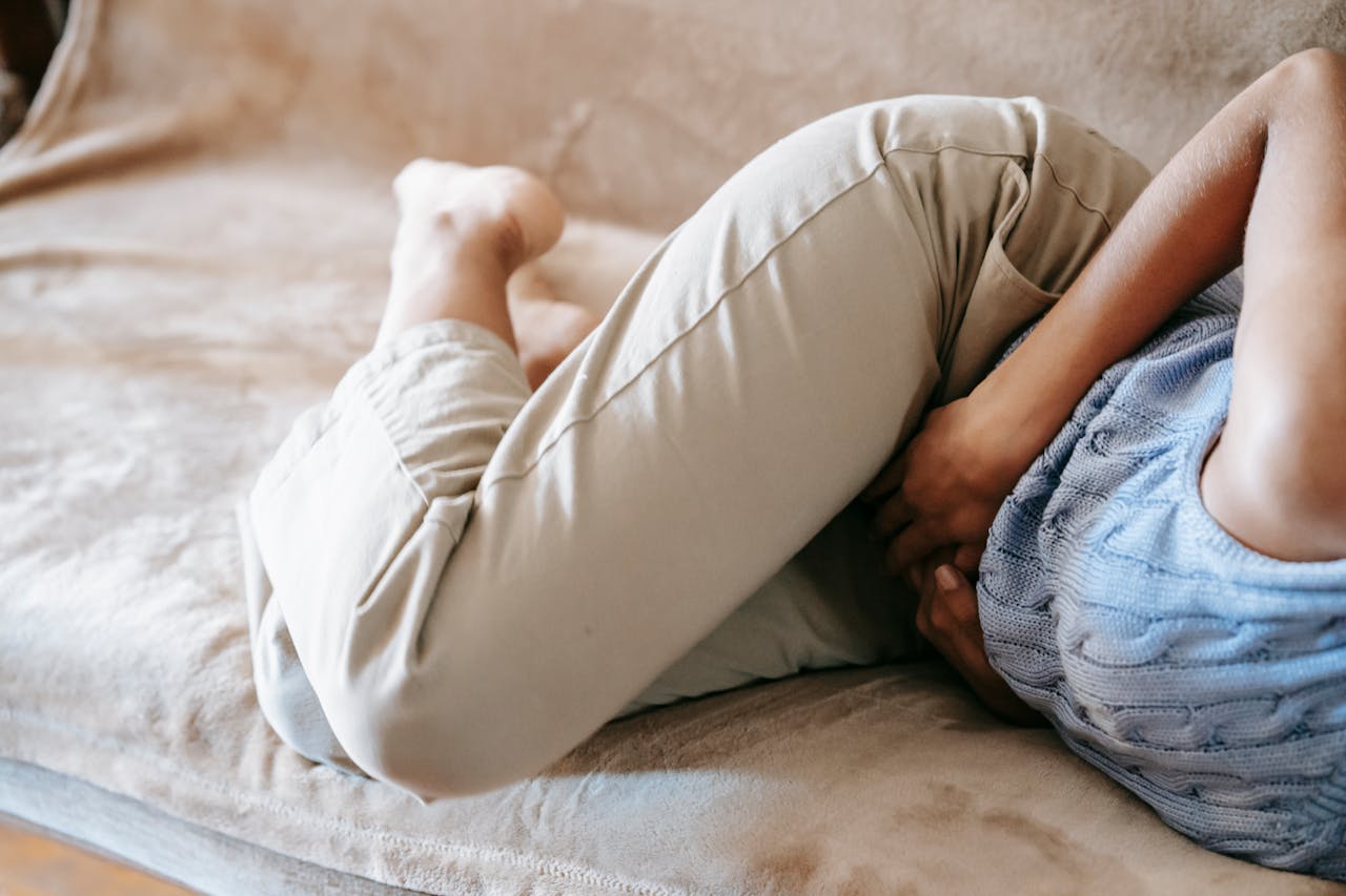 Mujer tumbada con hinchazón abdominal por la flora intestinal dañada