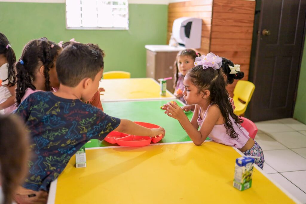 Niños almorzando saludablemente para combatir el estrés escolar y mejorar el rendimiento académico.