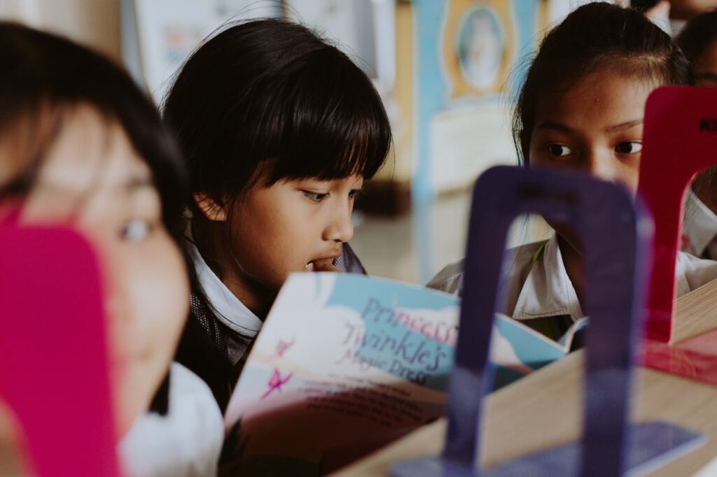 Niña concentrada mientras lee y mejora su rendimiento académico.